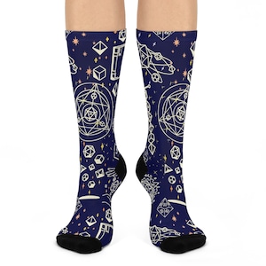 May include: A pair of blue socks with a white geometric pattern of stars, circles, and squares. The socks have a black toe and heel.