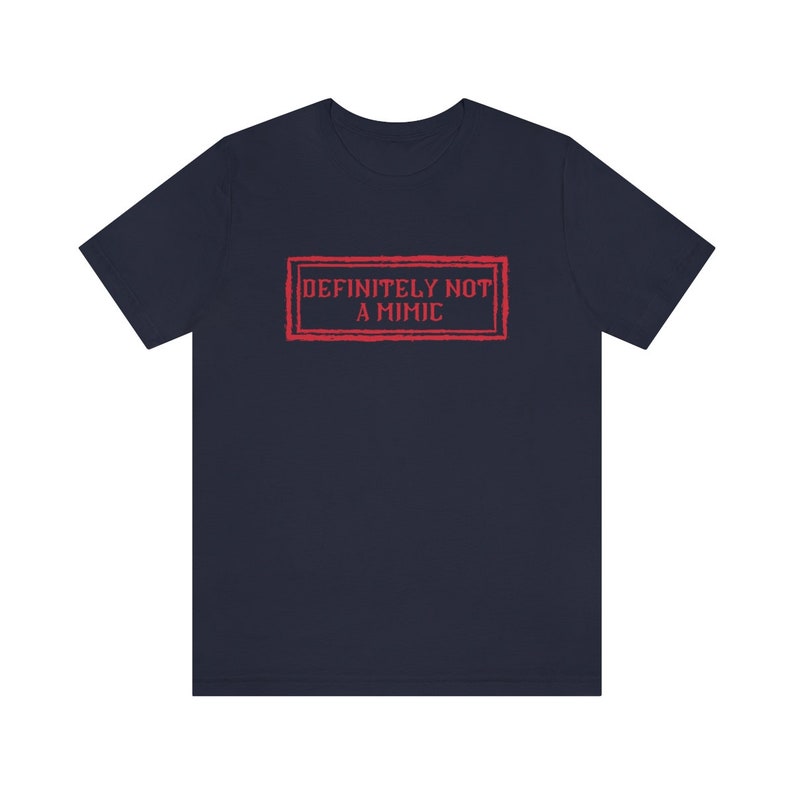 May include: A navy blue t-shirt with a red stamp that says "DEFINITELY NOT A MIMIC".