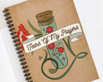 May include: A brown spiral notebook with a vintage design featuring a glass vial with a cork stopper. The vial contains red dice and is surrounded by flowers and a banner that reads "Tears of My Players".