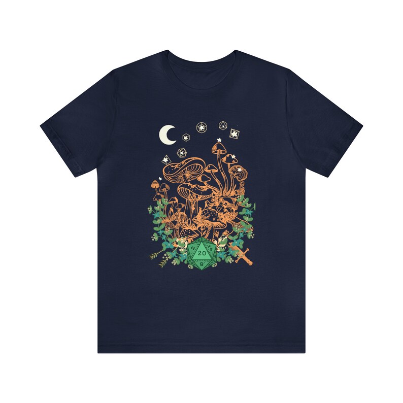 May include: Navy blue t-shirt with a graphic of mushrooms, a crescent moon, stars, and a green twenty-sided die. The graphic is surrounded by green foliage.