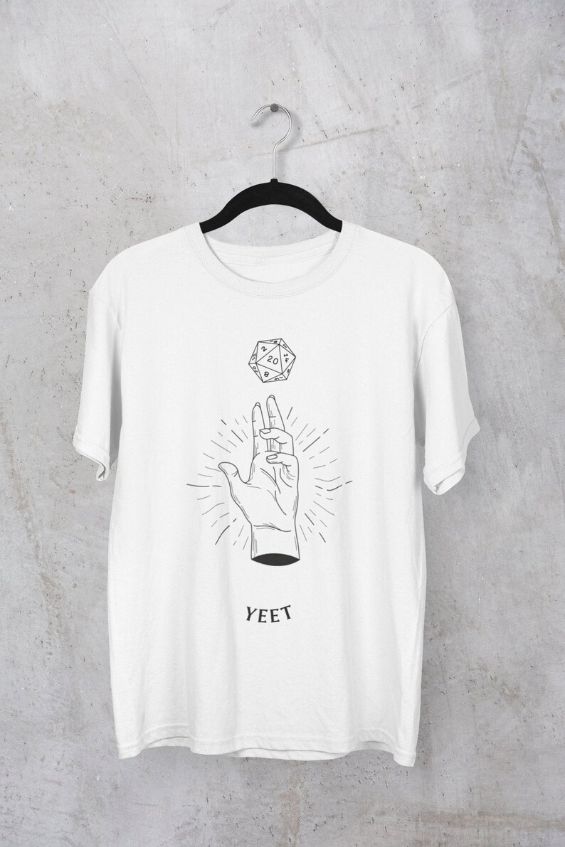May include: White t-shirt featuring a black and white illustration of a hand throwing a twenty-sided die. The text "YEET" is printed below the illustration.