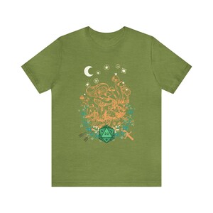 May include: Green t-shirt with a graphic of a crescent moon, stars, mushrooms, and a green 20-sided die.