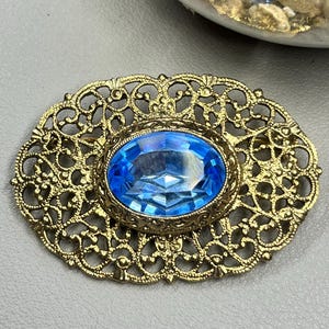 Vintage gold tone blue rhinestone filigree brooch