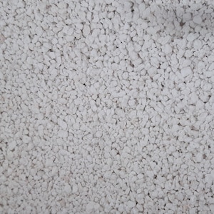 May include: A close-up image of a white, fine-grained, granular material. The material appears to be a type of gravel or sand.