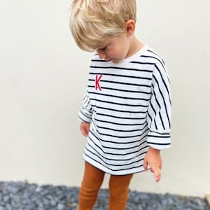 A soft, 100% cotton, kids’ Breton striped sweatshirt with a personalised appliqué embroidered initial or felt number of your choice.