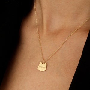 K&ouml;nnte beinhalten: Goldkette mit einem katzenf&ouml;rmigen Anh&auml;nger, auf dem "miau" steht.