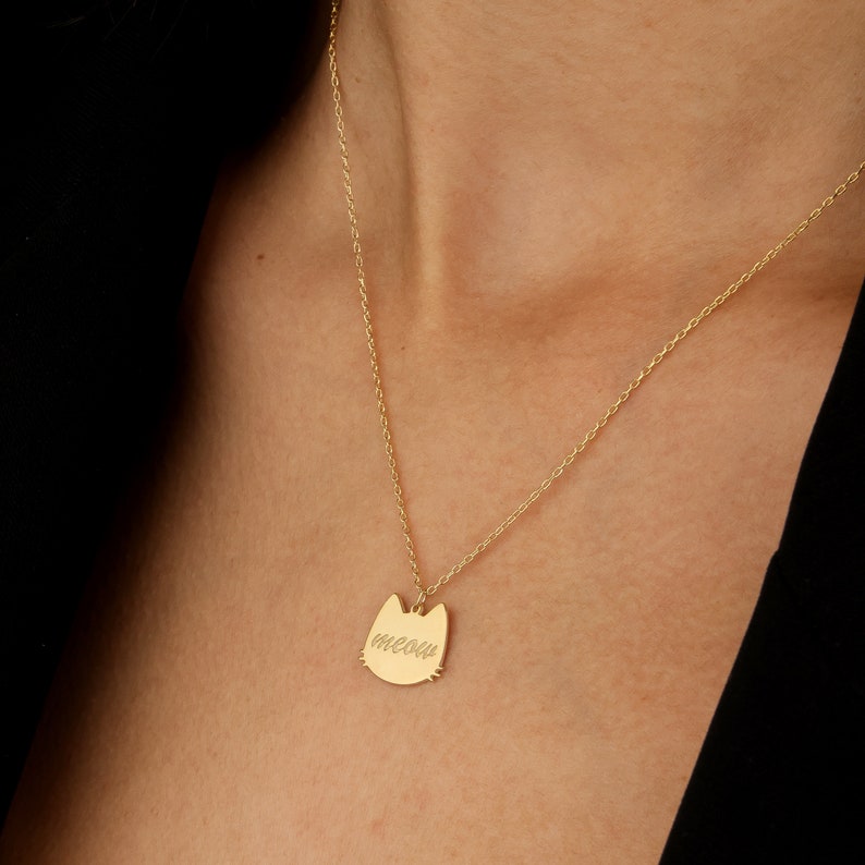 K&ouml;nnte beinhalten: Goldkette mit einem katzenf&ouml;rmigen Anh&auml;nger, auf dem "miau" steht.
