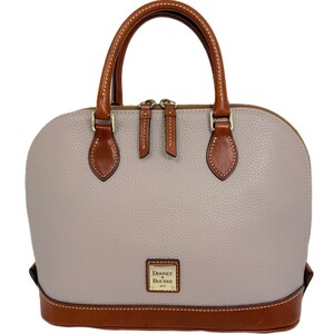 May include: A light gray dome-shaped handbag with brown leather accents. The bag features a top handle, a zipper closure, and a brown leather base. The brand name "Dooney & Bourke" is displayed on a small rectangular plaque.