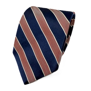 May include: A navy blue tie with alternating stripes of rust and white. The tie has a diagonal stripe pattern. The tie is folded and appears to be made of a smooth, possibly silk, material.