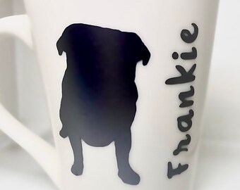 Könnte beinhalten: Weiße Keramiktasse mit einer schwarzen Silhouette eines Mops und dem Namen "Frankie" vertikal an der Seite.