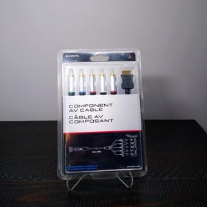 May include: A Sony Component AV Cable in a clear plastic package. The package includes a black HDMI connector and five color-coded RCA connectors. The text "COMPONENT AV CABLE" and "CÂBLE AV COMPOSANT" is printed on the packaging.