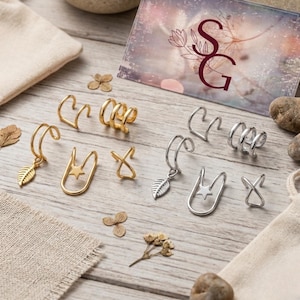 Peut inclure: Un ensemble de six bagues d'oreille en tons or et argent, présentant des motifs avec une feuille pendante, une étoile et un croisement. Le lot comprend des paires assorties dans les deux finitions métalliques, présentées avec une carte marquée SG.