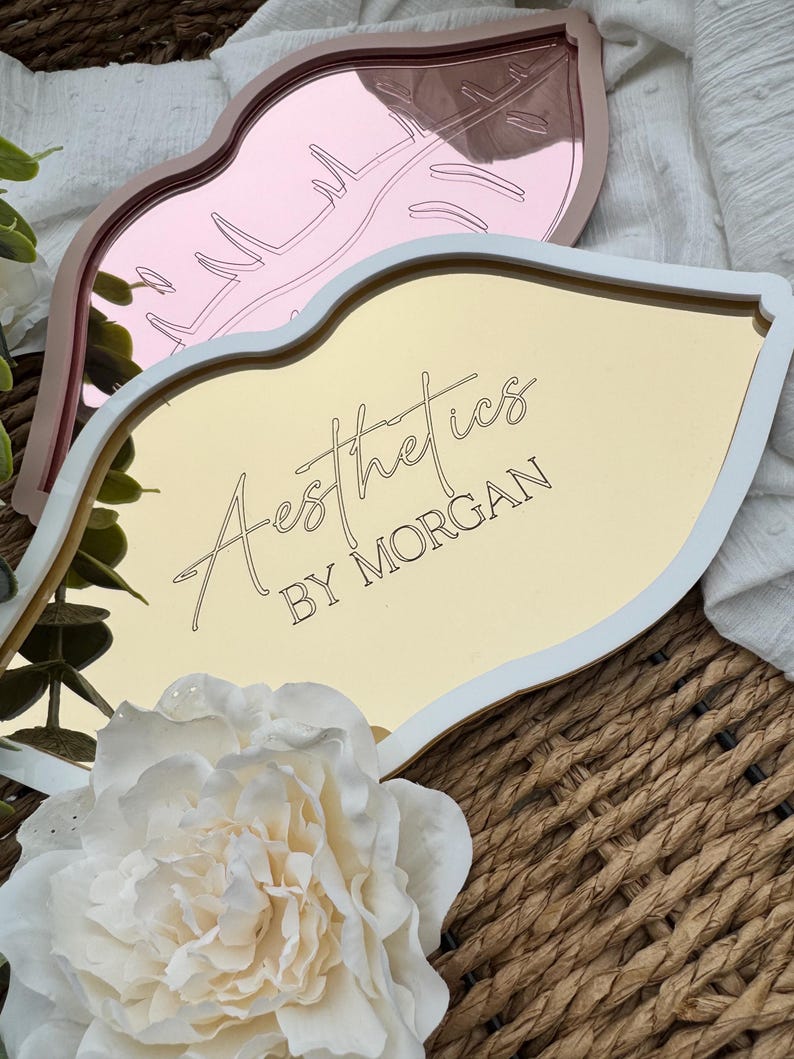 May include: Gold and pink lip-shaped trays with white trim. The gold tray has the text "Aesthetics by Morgan" on it.