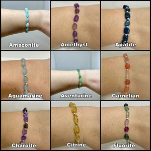Peut inclure: Neuf bracelets en pierres pr&eacute;cieuses diff&eacute;rentes, chacun avec une couleur et un type de pierre diff&eacute;rents. Les bracelets sont dispos&eacute;s en grille de trois rang&eacute;es et trois colonnes. Les pierres sont toutes de forme ovale et sont enfil&eacute;es sur des cha&icirc;nes en argent. Les bracelets sont &eacute;tiquet&eacute;s avec les noms des pierres pr&eacute;cieuses&nbsp;: Amazonite, Am&eacute;thyste, Apatite, Aigue-marine, Aventurine, Cornaline, Charoite, Citrine et Fluorite.