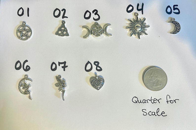 May include: Eight silver charm pendants with various designs, including a pentagram, a triquetra, a crescent moon, a sun, a heart, a fairy, and a crescent moon with a fairy. A US quarter is included for scale.