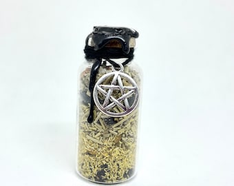 May include: A small glass bottle filled with dried herbs and spices. The bottle is sealed with a black wax and a silver pentacle charm. The contents are visible through the clear glass.