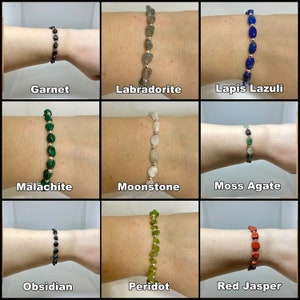 Peut inclure: Neuf bracelets en pierres pr&eacute;cieuses diff&eacute;rentes, chacun avec une couleur et un type de pierre diff&eacute;rents. Les bracelets sont montr&eacute;s sur le poignet d'une personne. Les pierres sont&nbsp;: grenat, labradorite, lapis-lazuli, malachite, pierre de lune, agate mousse, obsidienne, p&eacute;ridot et jaspe rouge.