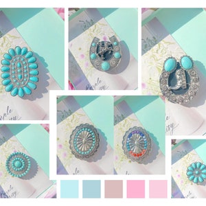 May include: Assortment of turquoise and silver jewelry pieces, including a horseshoe, a boot, and a variety of round and oval designs. The jewelry is displayed on a light blue background with floral accents.