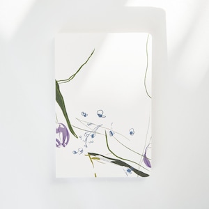 May include: A white card with a green, purple, and blue abstract floral design. The design features a few small flowers and a few larger flowers.
