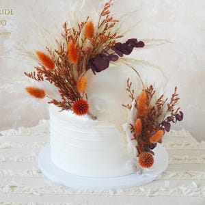 バーントオレンジのエキノプスドライストローフラワーケーキトッパー、ウェディングデコレーション、ドライ＆プリザーブドローズケーキトッパー、パンパスグラスウェディングデコレーション