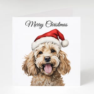 May include: A Christmas card with a watercolour illustration of a dog wearing a red Santa hat with white trim. The dog has light brown fur and a pink tongue. The words "Merry Christmas" are written above.