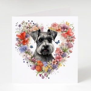 May include: A black and grey miniature schnauzer dog with a heart-shaped wreath of colorful flowers and butterflies around it.