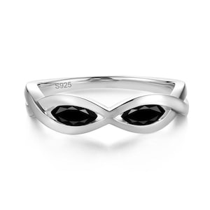 May include: A silver-toned ring featuring an infinity-style band with two marquise-cut black stones set within the metal loops. The interior of the band is clearly engraved with the text S925, indicating the metal composition of the jewelry piece.