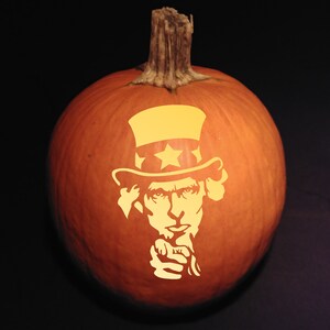 May include: A carved orange pumpkin with a stem, featuring a yellow silhouette of Uncle Sam pointing his finger. The design includes his iconic hat with a star. The pumpkin is set against a dark background, perfect for Halloween.