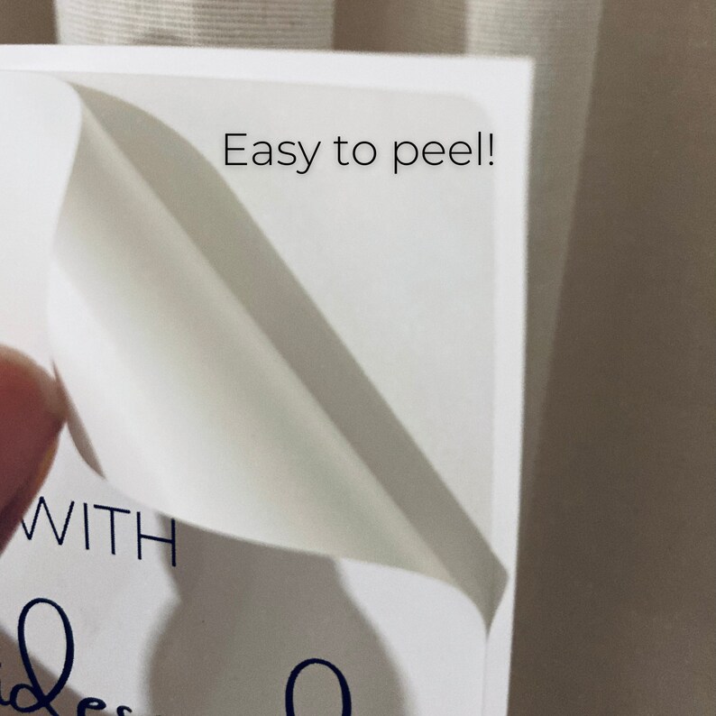 May include: Close-up of a white sticker with the text "Easy to peel!" and part of a handwritten script. The sticker is being peeled back, revealing a clean, white surface. The image suggests a product with easy-to-use labels.