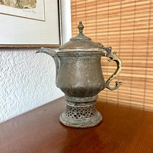 May include: A set of three ceramic mugs with a speckled, matte finish. The mugs are in shades of cream, light gray, and dark gray. Each mug has a simple, minimalist design and a rounded handle.