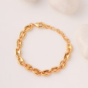 May include: A gold chain bracelet with a lobster clasp. The chain is made of oval links.