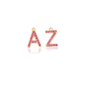 Può includere: Ciondoli a forma di lettera dorati con decorazioni in cristallo rosa. Le lettere sono A e Z.