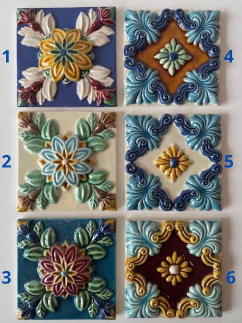 May include: Six square ceramic tiles with floral designs. Each tile features a raised, colorful pattern of flowers and leaves in shades of blue, yellow, green, white, and burgundy. The tiles are arranged in a grid.