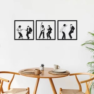 May include: Three framed wall art pieces with black and white silhouettes of dancing figures. Each frame has a black border and a white background. The figures are in different dance poses, creating a dynamic display. The art is displayed above a wooden table.