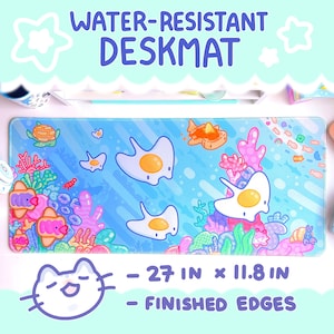 May include: A blue and pink water-resistant desk mat with a sea-themed design featuring cartoon sea creatures, coral reefs, and eggs. The mat measures 27 inches by 11.8 inches and has finished edges.