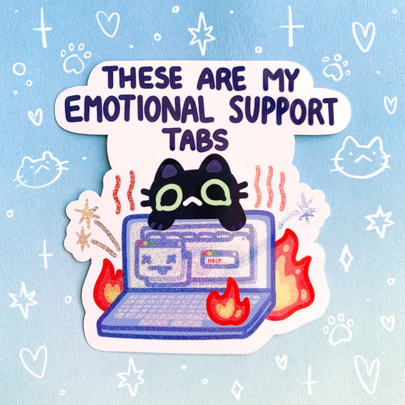 May include: A black cat with green eyes sits on a laptop with multiple browser tabs open. The laptop is on fire and the text "These are my emotional support tabs" is above the cat.