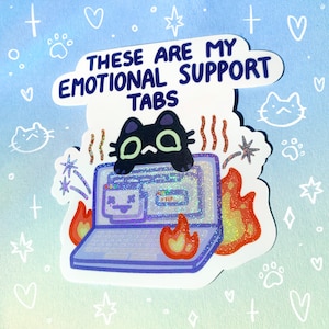 May include: A sticker with a black cat sitting on a laptop with flames coming out of the sides. The text on the sticker reads "These are my emotional support tabs".