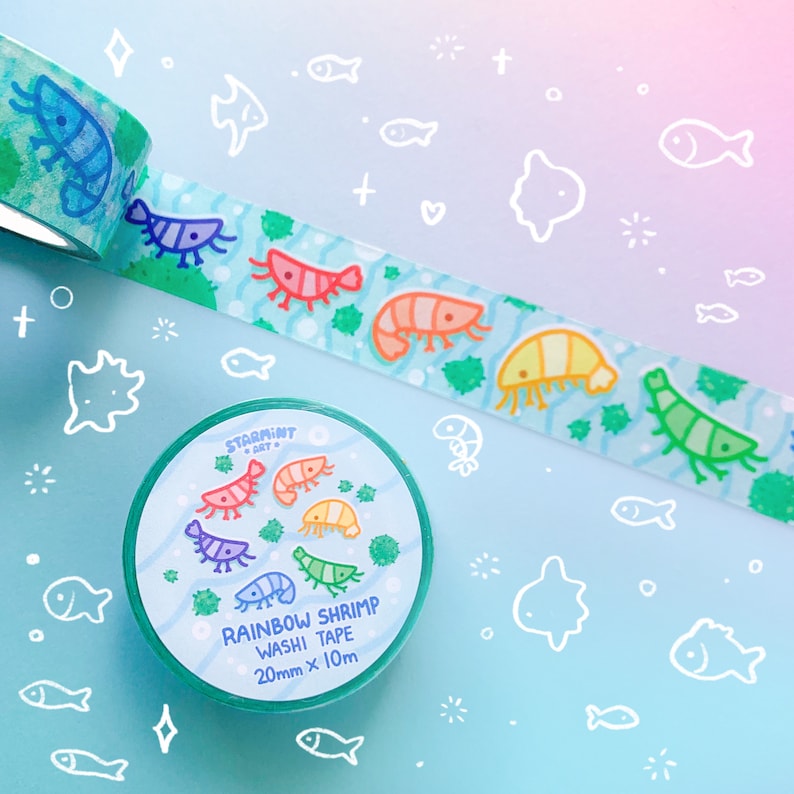 Puede incluir: Un rollo de cinta washi con un dise&ntilde;o de camarones arco&iacute;ris. La cinta tiene 20 mm de ancho y 10 m de largo. La cinta est&aacute; sobre un fondo blanco con un degradado azul y rosa.
