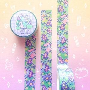 May include: A roll of green and purple washi tape with a repeating pattern of frogs wearing wizard hats, potion bottles, and mushrooms. The tape is 20mm wide and 10m long. The text on the tape reads "Starmint Art Washi Tape 20mm x 10m".