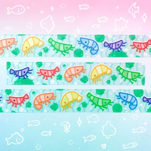 Puede incluir: Una hoja de cinta washi colorida con un patr&oacute;n repetido de camarones de dibujos animados sobre un fondo verde y azul. Los camarones est&aacute;n en un arco&iacute;ris de colores, incluyendo rojo, naranja, amarillo, verde, azul y morado.