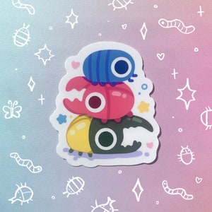 May include: A sticker featuring three cartoon beetles stacked on top of each other. The top beetle is blue with a single large eye, the middle beetle is red with a single large eye, and the bottom beetle is yellow, green, and black with a single large eye.