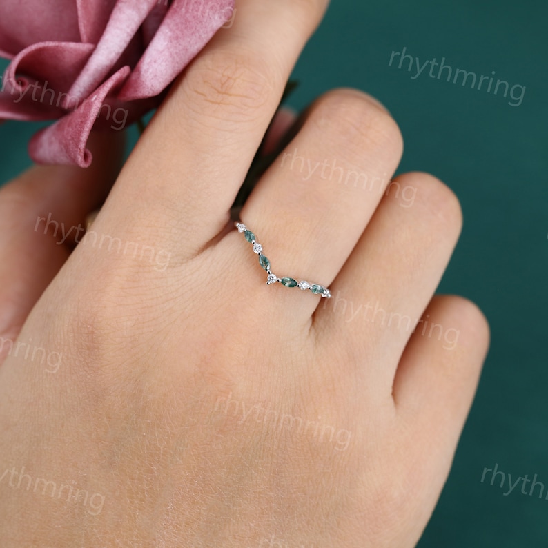 K&ouml;nnte beinhalten: Ein zarter Silberring mit einem V-f&ouml;rmigen Design, das mit kleinen gr&uuml;nen Edelsteinen und wei&szlig;en Diamanten besetzt ist.