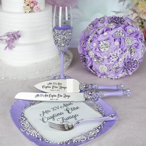 May include: Purple cake knife and server set with a purple and silver cake plate. The set is decorated with rhinestones and the handles are purple. The knives are engraved with the text "Mis XV A&ntilde;os Caylina Elise Zuniga March 11, 2023".