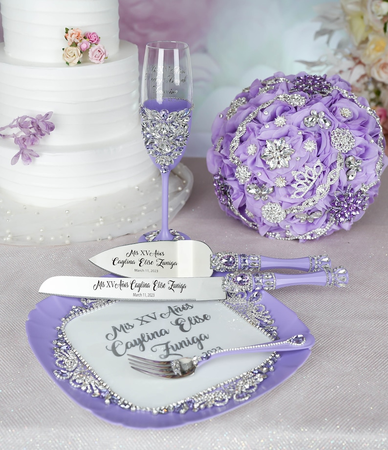 May include: Purple cake knife and server set with a purple and silver cake plate. The set is decorated with rhinestones and the handles are purple. The knives are engraved with the text "Mis XV A&ntilde;os Caylina Elise Zuniga March 11, 2023".