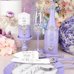 May include: Purple and silver Quincea&ntilde;era party decorations including a cake knife and server, a bottle of sparkling wine, a candle, a champagne flute, and a decorative plate. The decorations are personalized with the name "Dalila" and the date "3/18/2023".