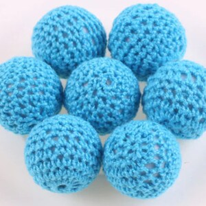 May include: Seven crocheted balls in a light blue color. The balls are made of a fine, open weave crochet thread.