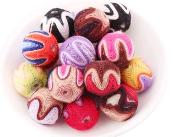 May include: A collection of colorful, patterned wooden beads. The beads are made of wood and have a variety of colors and patterns, including red, blue, green, yellow, and brown.
