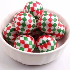 May include: A bowl of red and green checkered wooden beads. The beads are round and have a glossy finish.