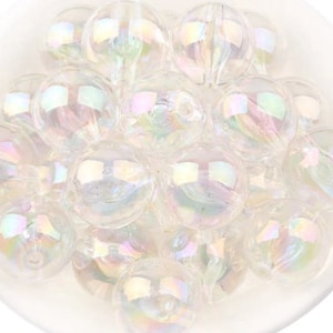 May include: A collection of iridescent glass ornaments in various sizes. The ornaments are clear with a rainbow sheen.