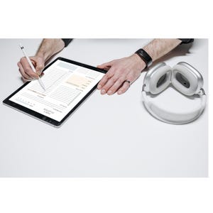 May include: A black tablet displaying a digital daily planner template with sections for top priority, to-do list, and meal plan. A white stylus is held against the screen, and a pair of silver over-ear headphones sits to the right.